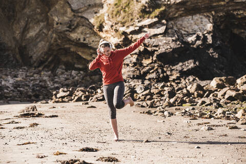 Female jogger dancing at the beach with headphones stock photo