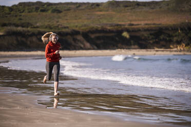 Female jogger at the beach with headphones - UUF19012