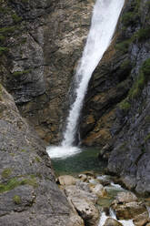 Blick auf einen Wasserfall auf einem Berg im Wald bei Füssen, Deutschland - JTF01314