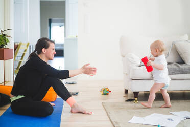 Side view of mother gesturing while calling daughter in living room at home office - MASF13443