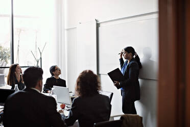 Geschäftsfrau bei einer Präsentation vor Kollegen in einer Bürobesprechung - MASF13544