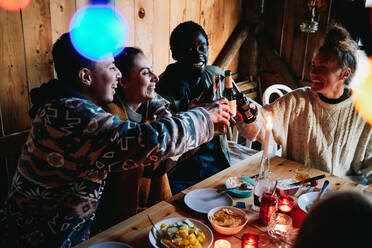 Hohe Winkel Ansicht der glücklichen männlichen und Freunde Toasting Bierflaschen in Blockhaus - MASF13575