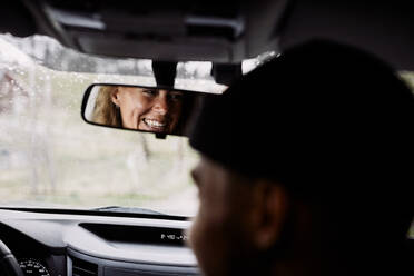 Reflexion der fröhlichen Frau genießt Road Trip mit männlichen Freund im Auto - MASF13671