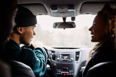 Männliche und weibliche Freunde unterhalten sich während der Fahrt im Auto - MASF13673