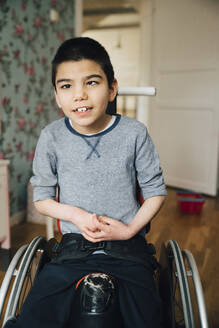 Porträt eines autistischen Jungen, der zu Hause im Rollstuhl sitzt - MASF13890
