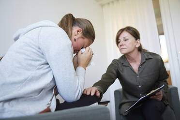 Senior-Therapeutin tröstet depressives Teenager-Mädchen bei Workshop - MASF13930