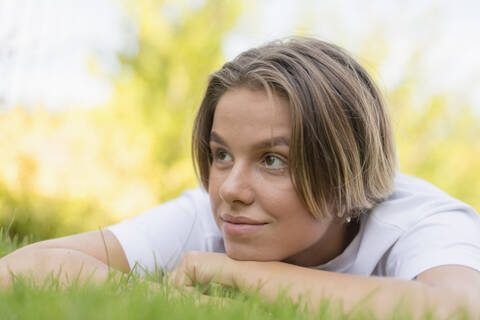Junge Frau liegt im Gras, lizenzfreies Stockfoto
