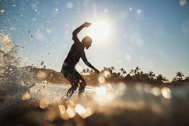 Männlicher Surfer reitet auf einer Welle im sonnigen Sommermeer, Sayulita, Nayarit, Mexiko - FSIF04377