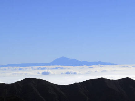 Luftaufnahme Berg gegen blauen Himmel über Wolken, Santa Cruz de La Palma, Spanien - FSIF04425