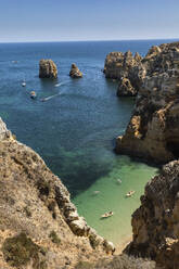 Luftaufnahme Touristen beim Bootfahren entlang der Klippen, Lagos, Algarve, Portugal - FSIF04462