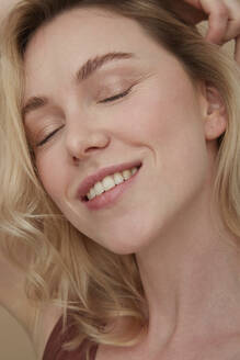 Portrait of happy blond woman wearing with eyes closed - PGCF00011