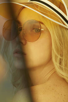 Portrait of young blond woman wearing sunglasses in summer - PGCF00025