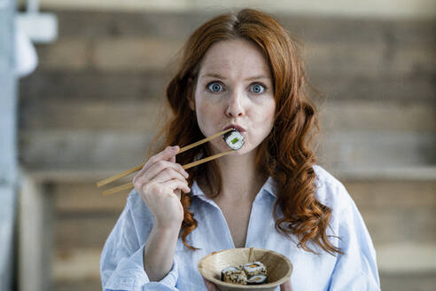 Portrait of redheaded woman eating sushi - KNSF06511