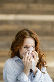 Redheaded woman blowing nose - KNSF06530