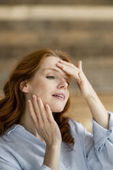 Portrait of redheaded woman touching her face - KNSF06532