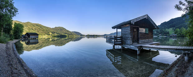 Bootshäuser am Schliersee vor strahlend blauem Himmel, Mangfallgebirge, Deutschland - STSF02251