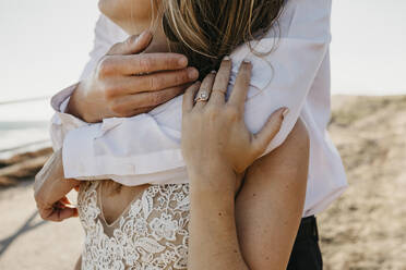 Close-up of affectionate bride and groom hugging outdoors - LHPF00787