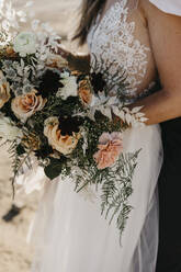 Elegant bride holding bridal bouquet outdoors - LHPF00788