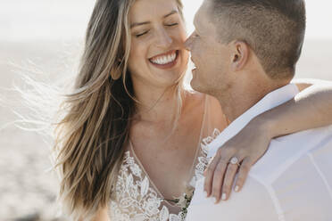 Happy affectionate bride and groom hugging outdoors - LHPF00798