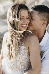 Happy affectionate bride and groom hugging outdoors - LHPF00803