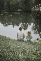 Mutter und Tochter sitzen am Flussufer - DWF00503