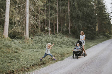 Mutter mit Tochter und Baby im Kinderwagen im Wald - DWF00511