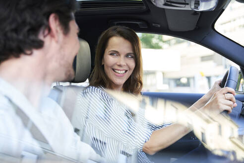 Happy couple in a car with woman driving - PNEF01976