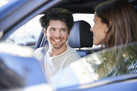 Glückliches Paar in einem Auto mit Frau am Steuer, lizenzfreies Stockfoto