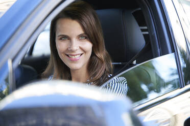 Porträt einer lächelnden Frau am Steuer eines Autos - PNEF01983