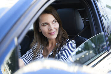 Porträt einer lächelnden Frau am Steuer eines Autos - PNEF01984