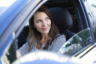 Portrait of smiling woman driving car - PNEF01984