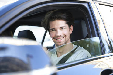 Portrait of smiling man driving car - PNEF01987