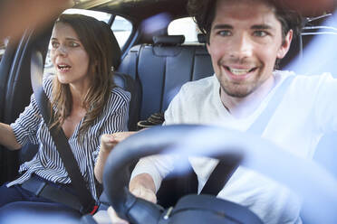 Shocked couple in a car with man driving - PNEF01991