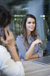 Portrait of confident businesswoman and man on cell phone in the city - PNEF02000