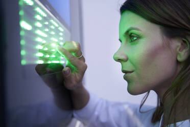 Nahaufnahme einer Frau, die einen Touchscreen mit grüner LED berührt - PNEF02077