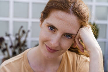 Portrait of smiling redheaded young woman with freckles - AFVF03958