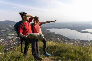 Young couple in the mountains, looking at view - MCVF00009