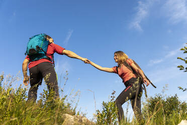 Junges Paar beim Wandern auf einer Bergwiese - MCVF00011
