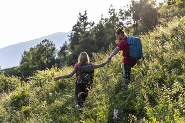 Junges Paar beim Wandern auf einer Bergwiese - MCVF00012