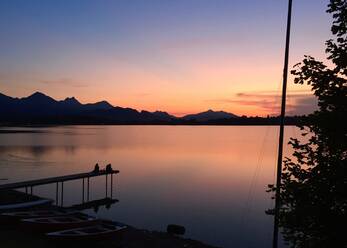 Blick auf den Forggensee gegen den Himmel bei Sonnenuntergang, Füssen, Deutschland - JTF01330