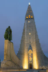 Die Hallgrims-Kirche mit einer Statue von Leif Erikson im Vordergrund, beleuchtet bei Nacht, Reykjavik, Island, Polarregionen - RHPLF08960