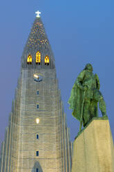 Die Hallgrims-Kirche mit einer Statue von Leif Erikson im Vordergrund, beleuchtet bei Nacht, Reykjavik, Island, Polarregionen - RHPLF08961