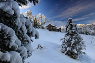 Der schneebedeckte Gipfel des Sass De Putia umrahmt die Holzhütte und den Wald in der Morgendämmerung, Passo Delle Erbe, Fünser Tal, Südtirol, Italien, Europa - RHPLF09010