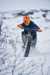 Mann radelt im Schnee - JOHF00246