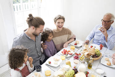 Glückliche Großfamilie beim Mittagessen zu Hause - MJFKF00022