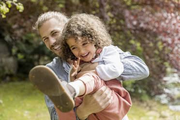 Happy father having fun with son in garden - MJFKF00025