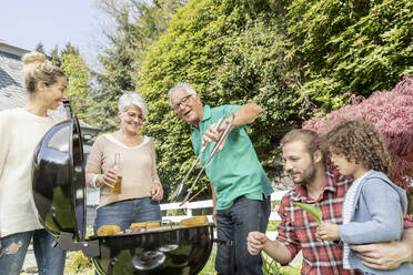 Großfamilie beim Grillen im Garten - MJFKF00047