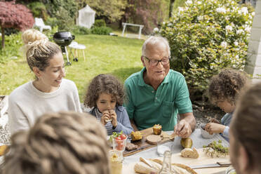 Extended family having lunch in garden - MJFKF00055