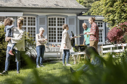 Großfamilie beim Grillen im Garten - MJFKF00078