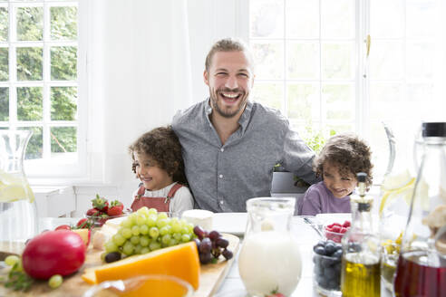 Happy father with two sons having lunch at home - MJFKF00107